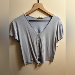Button down short- sleeve with tie details at bottom.